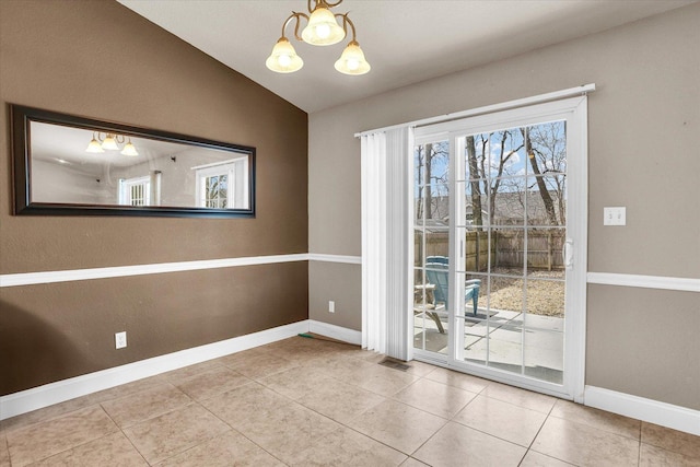 unfurnished dining area with vaulted ceiling, a notable chandelier, tile patterned flooring, and baseboards