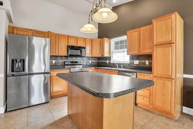 kitchen with light tile patterned flooring, stainless steel appliances, decorative backsplash, a center island, and dark countertops