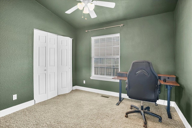 office with carpet floors, visible vents, vaulted ceiling, ceiling fan, and baseboards