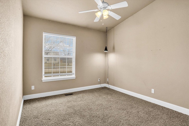 empty room with ceiling fan, carpet flooring, visible vents, baseboards, and vaulted ceiling