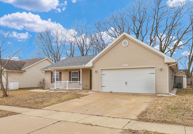 ranch-style home with driveway, covered porch, a garage, and central AC