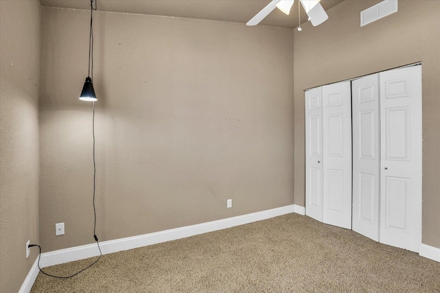 unfurnished bedroom with carpet, a closet, visible vents, ceiling fan, and baseboards