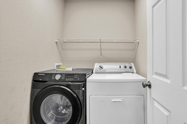 clothes washing area with washer and dryer and laundry area