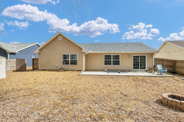 back of property with a fenced backyard, a patio, and a fire pit