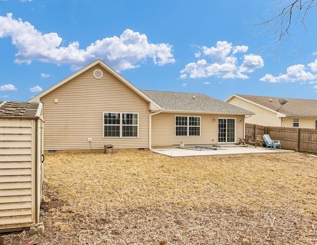 rear view of property featuring a patio, crawl space, and fence