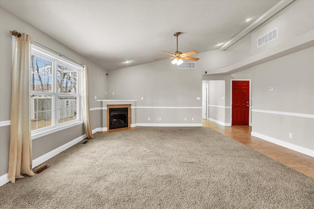 unfurnished living room featuring a fireplace with flush hearth, visible vents, baseboards, and a ceiling fan