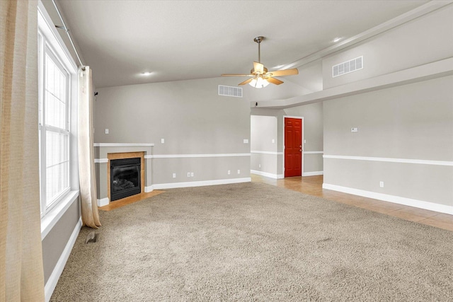 unfurnished living room featuring carpet, visible vents, a fireplace, and ceiling fan