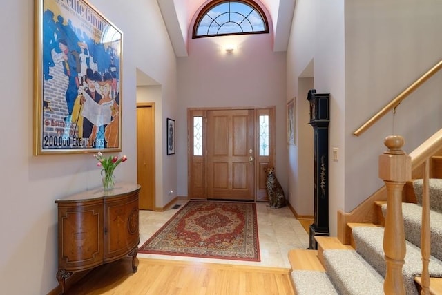 foyer with a towering ceiling and light hardwood / wood-style flooring