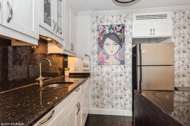 kitchen featuring sink, white cabinets, and refrigerator