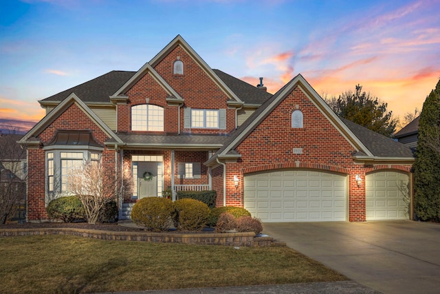 view of front of house featuring a garage, a lawn, and covered porch