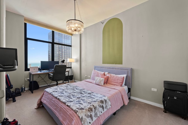 carpeted bedroom with a notable chandelier