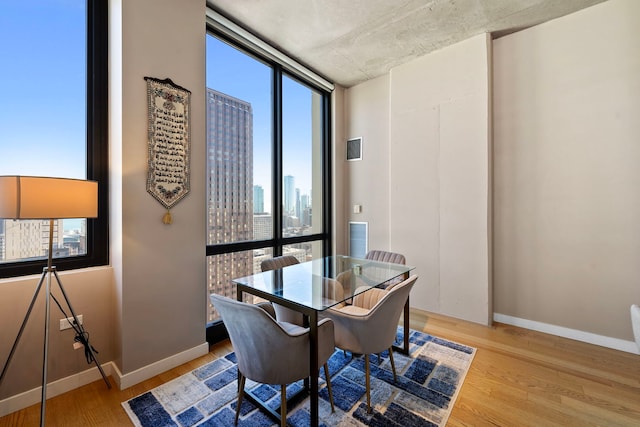 dining area with hardwood / wood-style floors and a wall of windows