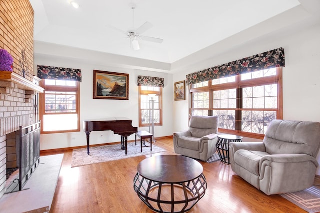 living area with plenty of natural light, a brick fireplace, and light wood-style flooring