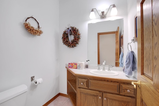 half bath with tile patterned floors, toilet, vanity, and baseboards