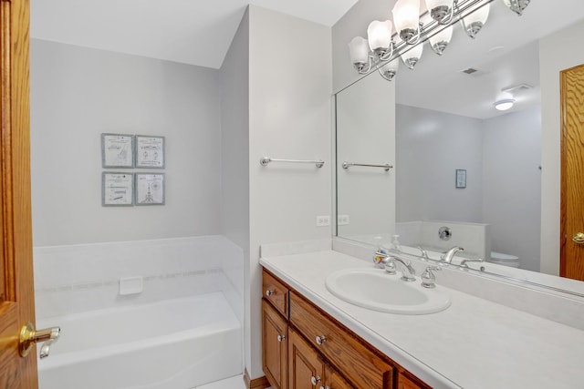 full bath featuring vanity, a garden tub, and toilet