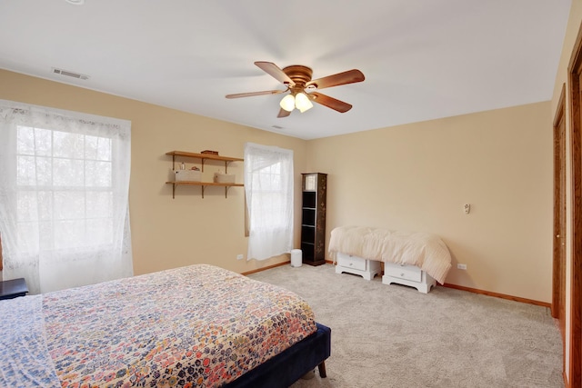 carpeted bedroom with visible vents, baseboards, and ceiling fan