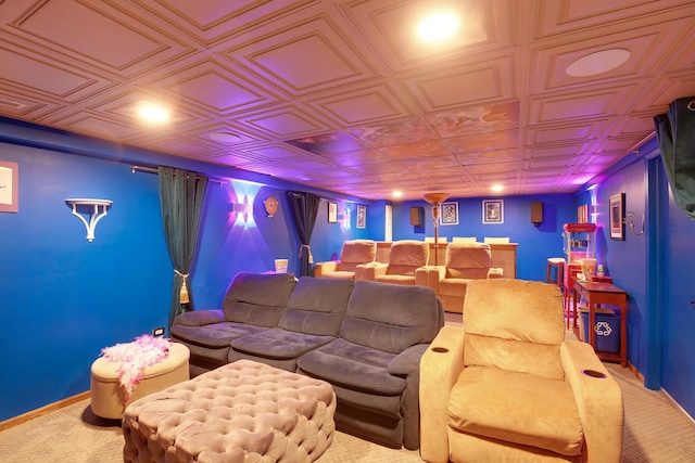 carpeted home theater with an ornate ceiling and baseboards