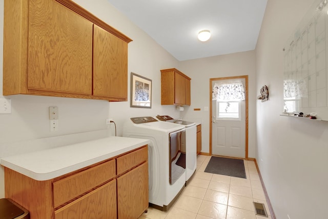 washroom with washing machine and clothes dryer, visible vents, cabinet space, and baseboards