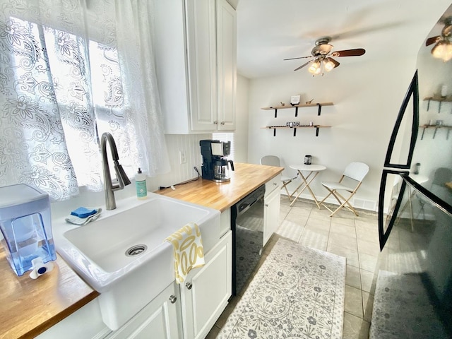 kitchen featuring light tile patterned flooring, white cabinetry, sink, ceiling fan, and black appliances