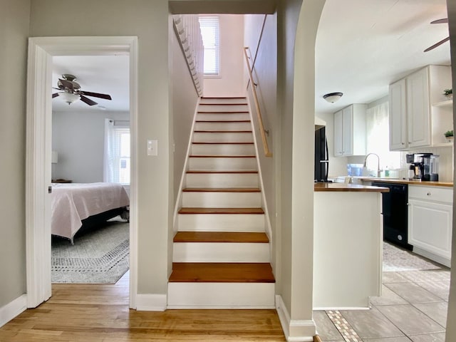 stairs featuring hardwood / wood-style flooring, plenty of natural light, and ceiling fan