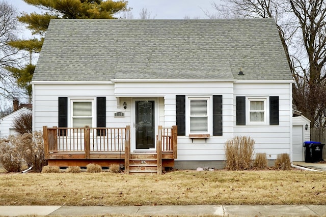 cape cod home featuring a front yard