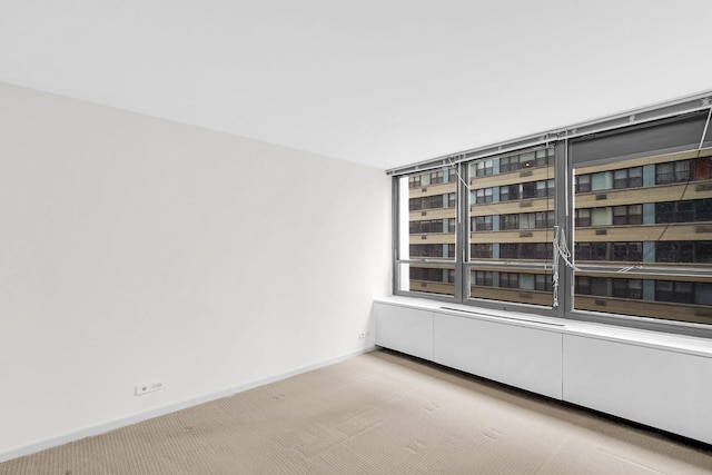 carpeted spare room featuring baseboards