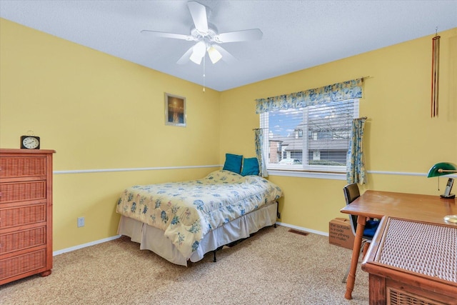 bedroom featuring a textured ceiling, light colored carpet, and ceiling fan