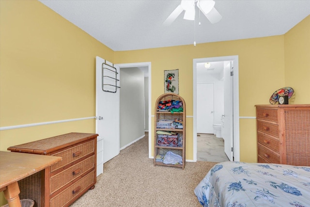 carpeted bedroom with ceiling fan and ensuite bath