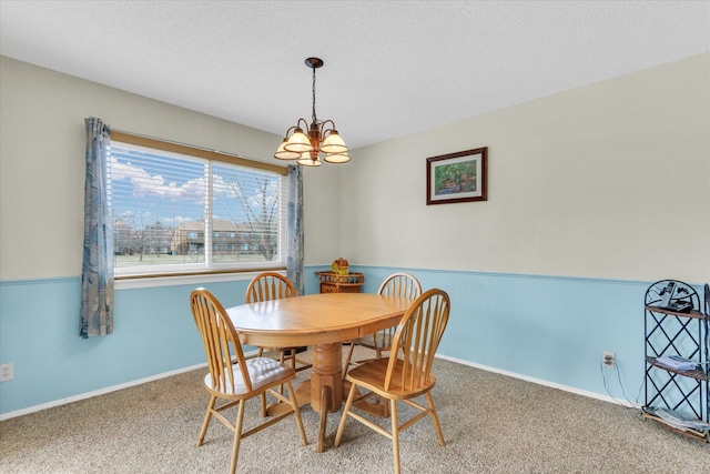 dining area with a chandelier, carpet floors, and a textured ceiling