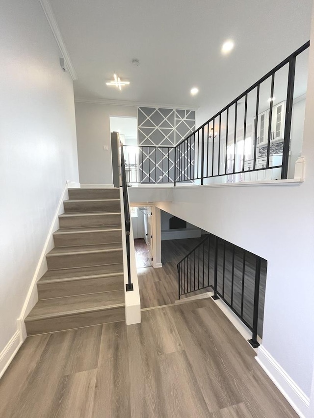 staircase featuring hardwood / wood-style flooring and crown molding