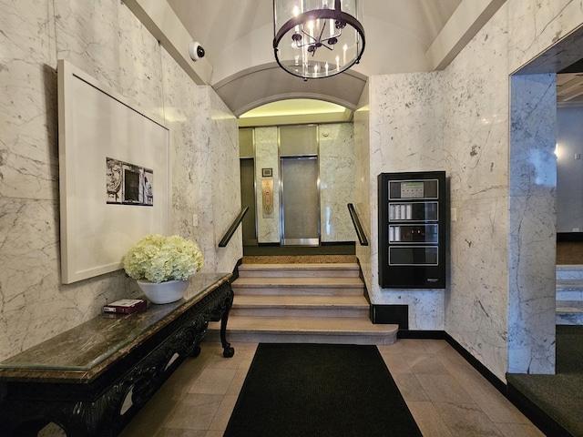 interior space with stairs, a chandelier, and elevator