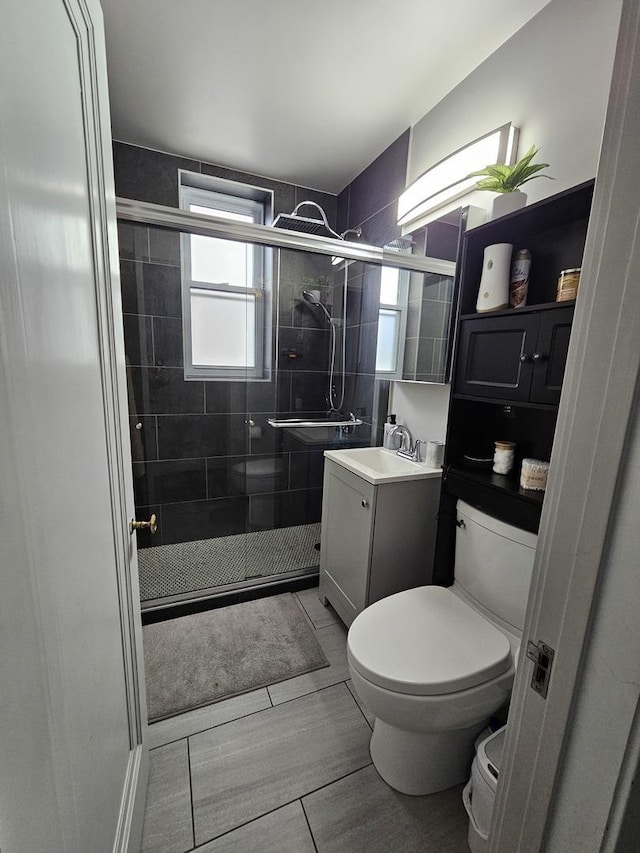 full bathroom featuring vanity, a shower stall, and toilet