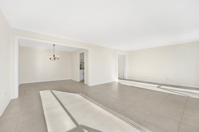 tiled empty room with a notable chandelier