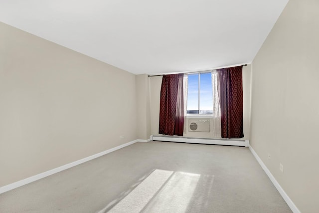 carpeted spare room with a baseboard heating unit