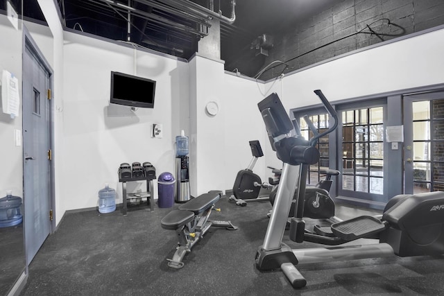 exercise room with a towering ceiling