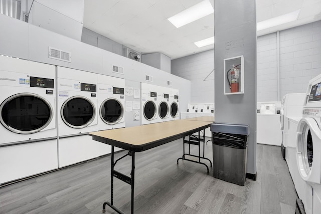 laundry room featuring separate washer and dryer and light hardwood / wood-style flooring