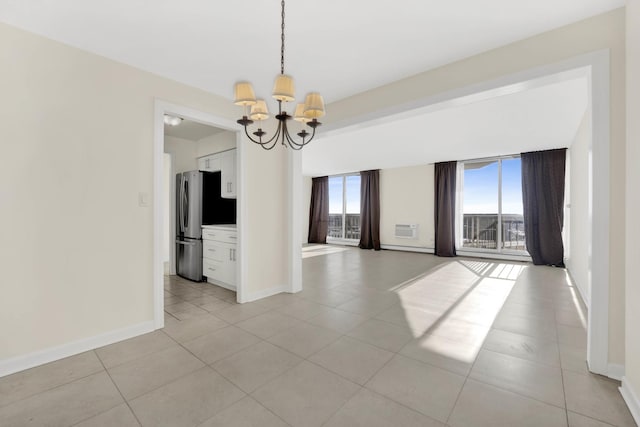 tiled empty room featuring an inviting chandelier and a wealth of natural light