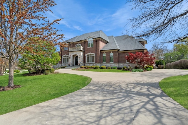6 Ivy Ln, Oak Brook, IL 60523 - french country inspired facade featuring curved driveway, stone siding, a front yard, and a balcony