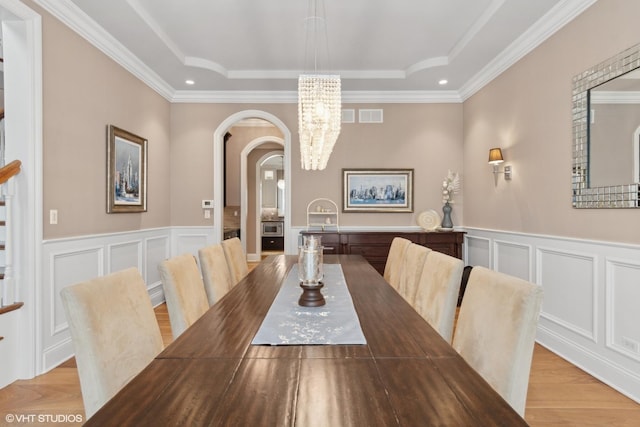 6 Ivy Ln, Oak Brook, IL 60523 - dining space with arched walkways, a chandelier, a raised ceiling, and a decorative wall