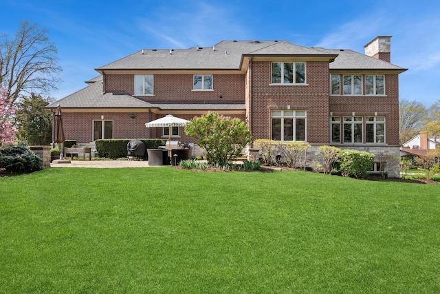 6 Ivy Ln, Oak Brook, IL 60523 - back of property featuring brick siding, a patio area, a yard, and a chimney