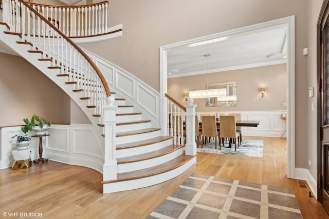 6 Ivy Ln, Oak Brook, IL 60523 - stairway featuring an inviting chandelier, crown molding, a decorative wall, and wood finished floors