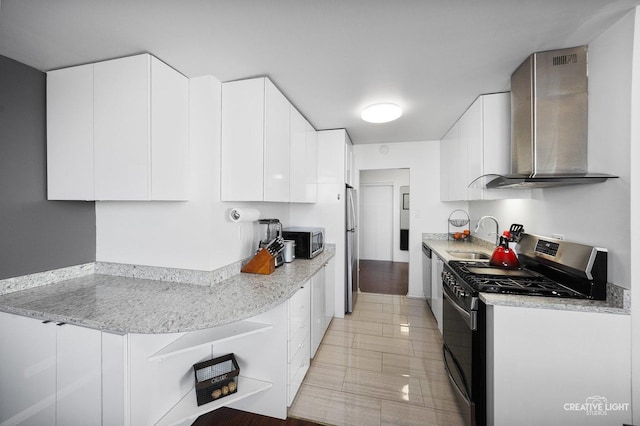 kitchen featuring white cabinetry, stainless steel appliances, sink, and wall chimney range hood