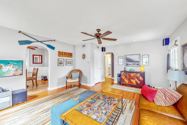 living room featuring light hardwood / wood-style flooring and ceiling fan