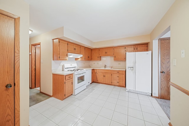 kitchen with light tile patterned flooring, white appliances, sink, and backsplash