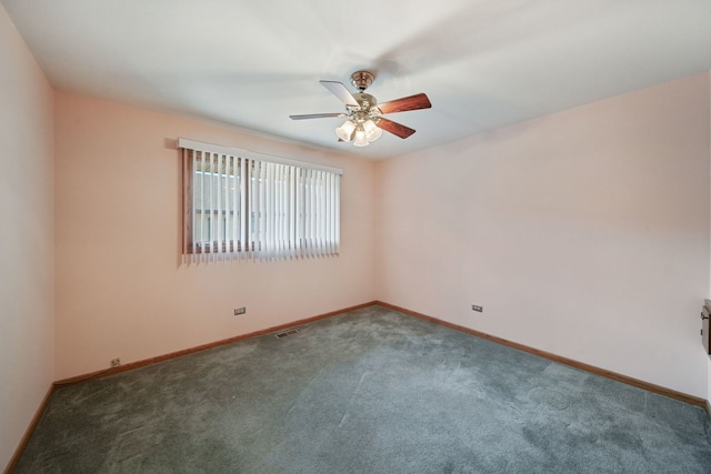 spare room with ceiling fan and dark colored carpet