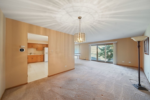 unfurnished living room with a chandelier, sink, and light carpet