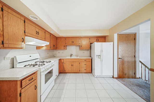 kitchen featuring sink, light tile patterned floors, backsplash, and white appliances