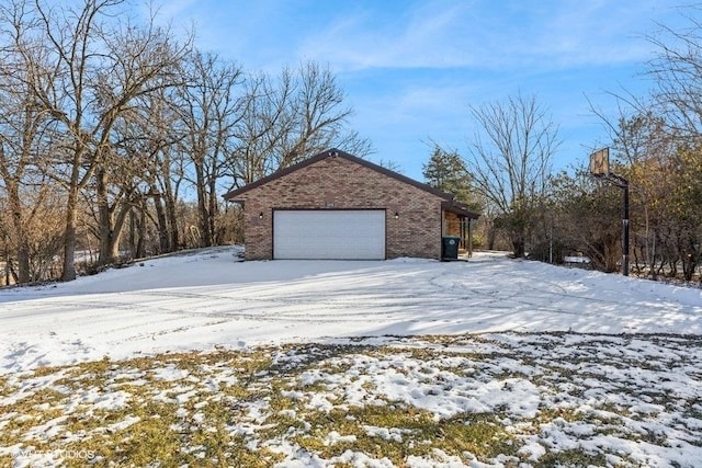 view of snowy exterior with a garage