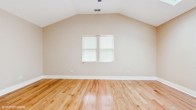 unfurnished room with hardwood / wood-style flooring and lofted ceiling