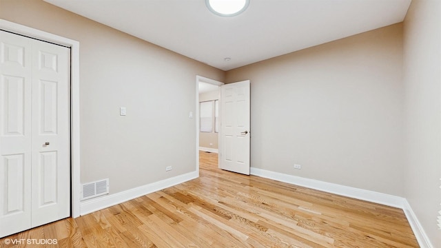 unfurnished bedroom featuring light hardwood / wood-style floors and a closet